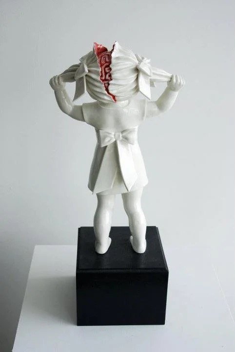 sculpture in marble of a little girl pulling her head apart by yanking on her pigtails - yankee doodle dandy deluxe